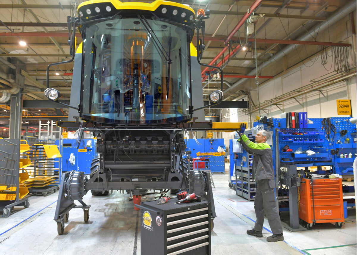 Arto Jaakkola asentaa paikoilleen leikkuupuimurin terassilevy&auml;.