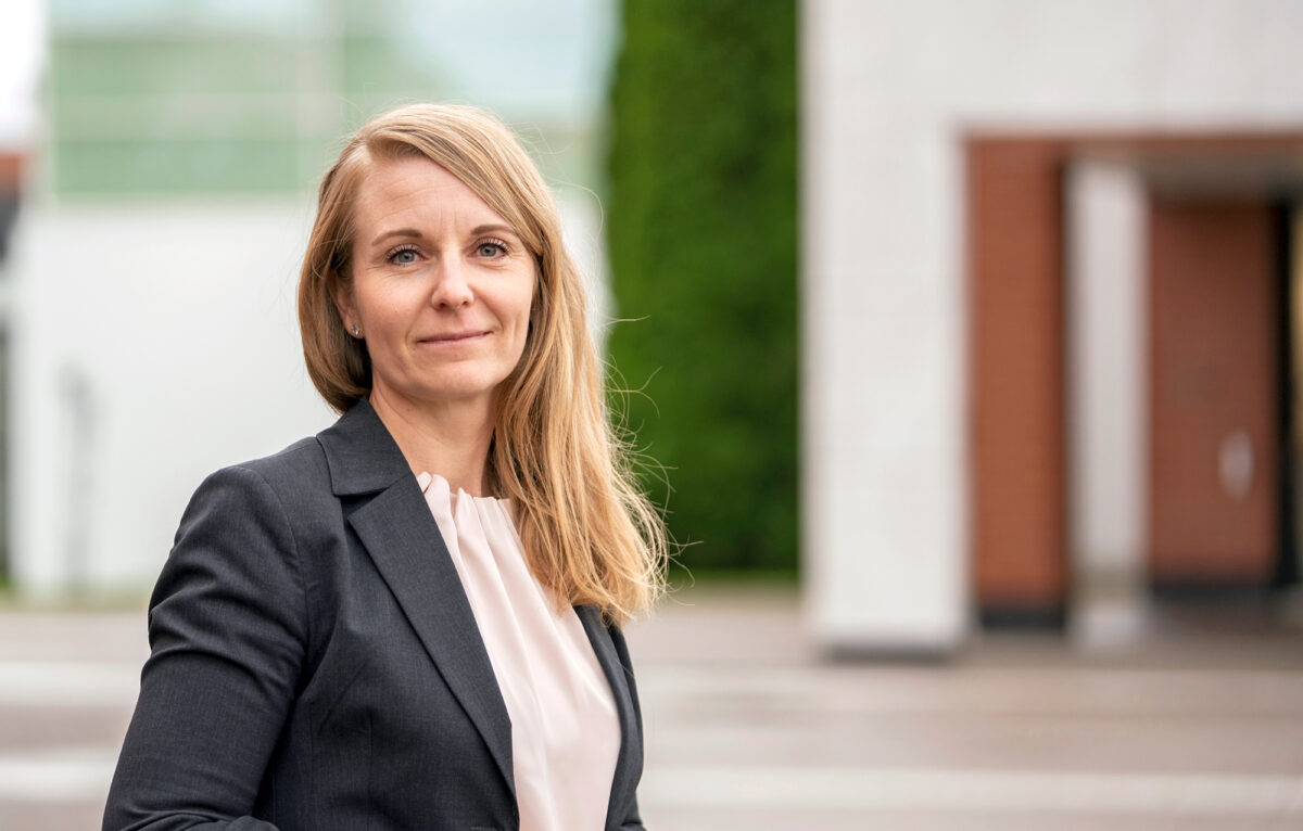 Johanna Jansson seisoo toimistorakennuksen edessä ulkona.