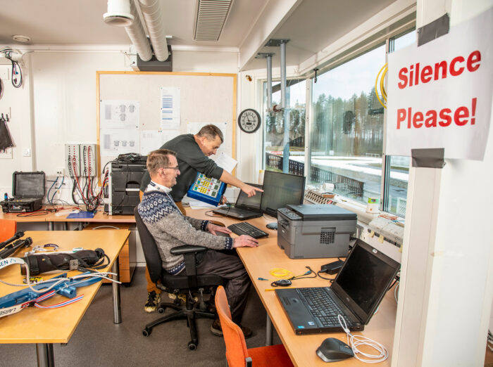 Maailmancup-tapahtuman hermokeskus on stadionin päärakennuksen ajanotto- tila. Ajanottopalvelun  henkilöt muun muassa yhdistävät tv-grafiikan ja ampumatulokset. Kimmo Turunen ja maailmancup-tapahtuman ajanoton tukihenkilö ja tietoliikenneyhteyksistä vastaava Pekka Hautala (edessä).