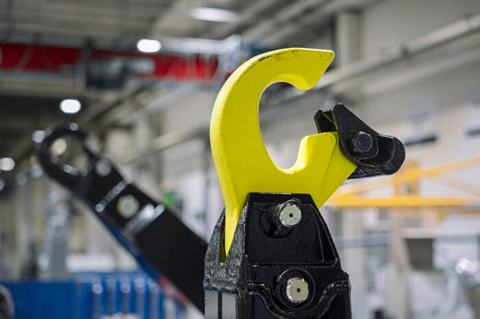 Koukkulaite kiinnittyy tartuntakaareen ja nostaa lavan kyytiin.