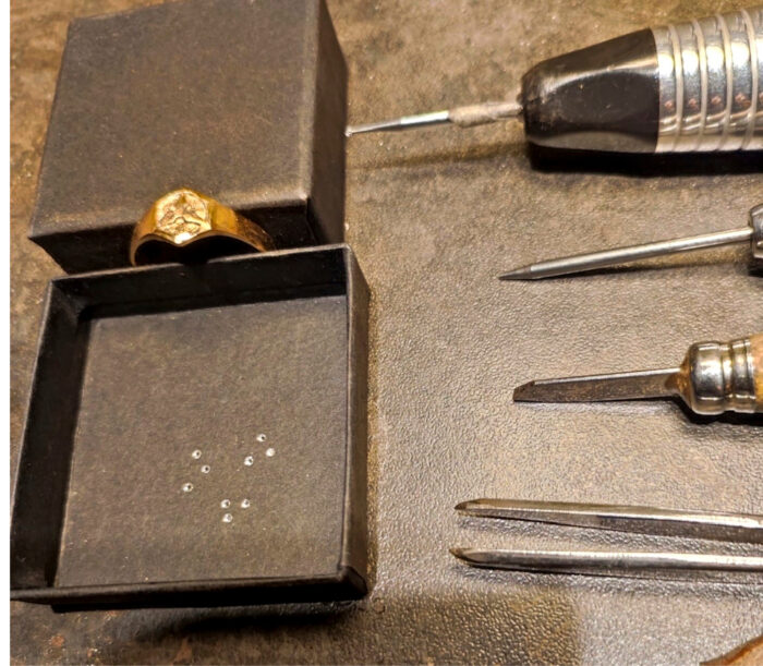 Sormusten valmistaminen on tarkkaa käsityötä. Timantti-istutuksia odottava insinöörisormus.